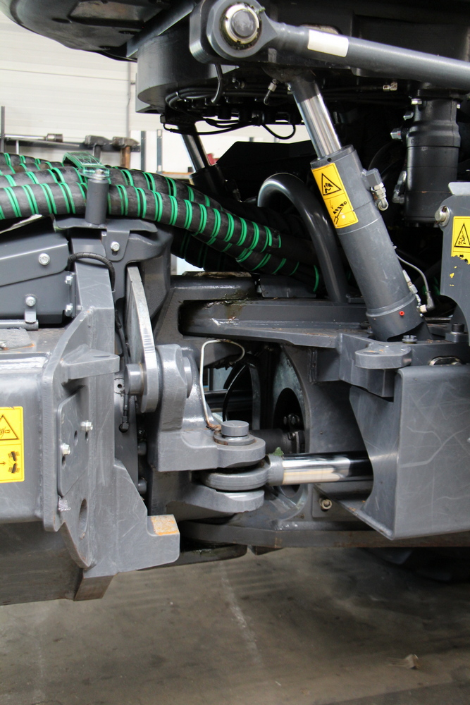 Le frein à friction au point d'articulation fixe automatiquement les deux parties du châssis pendant la récolte. Ce frein est mécanique sur la série G, tandis que la série H est équipée d'un frein à friction hydraulique.