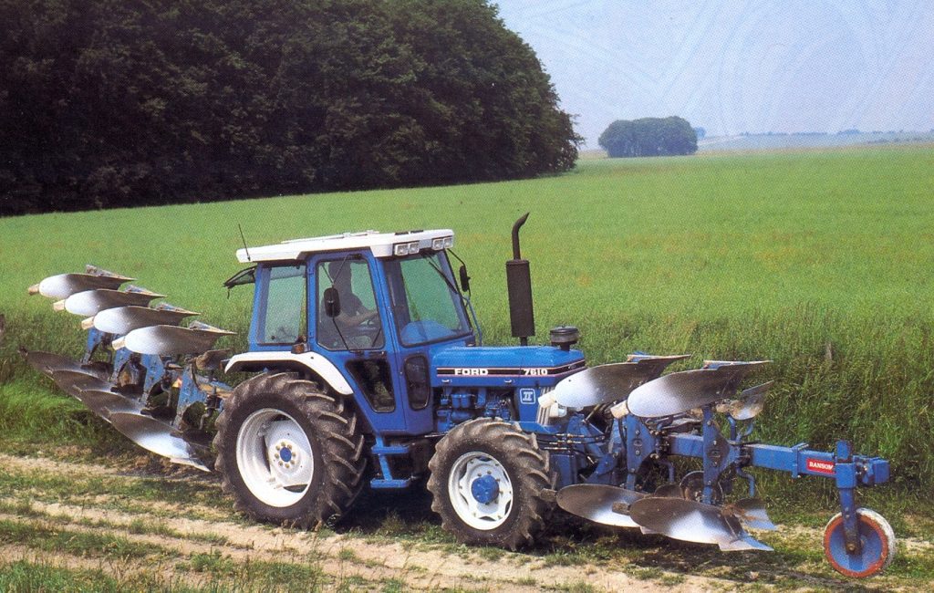 Un Ford 7610 avec une charrue frontale 2 corps et une charrue arrière 4 corps