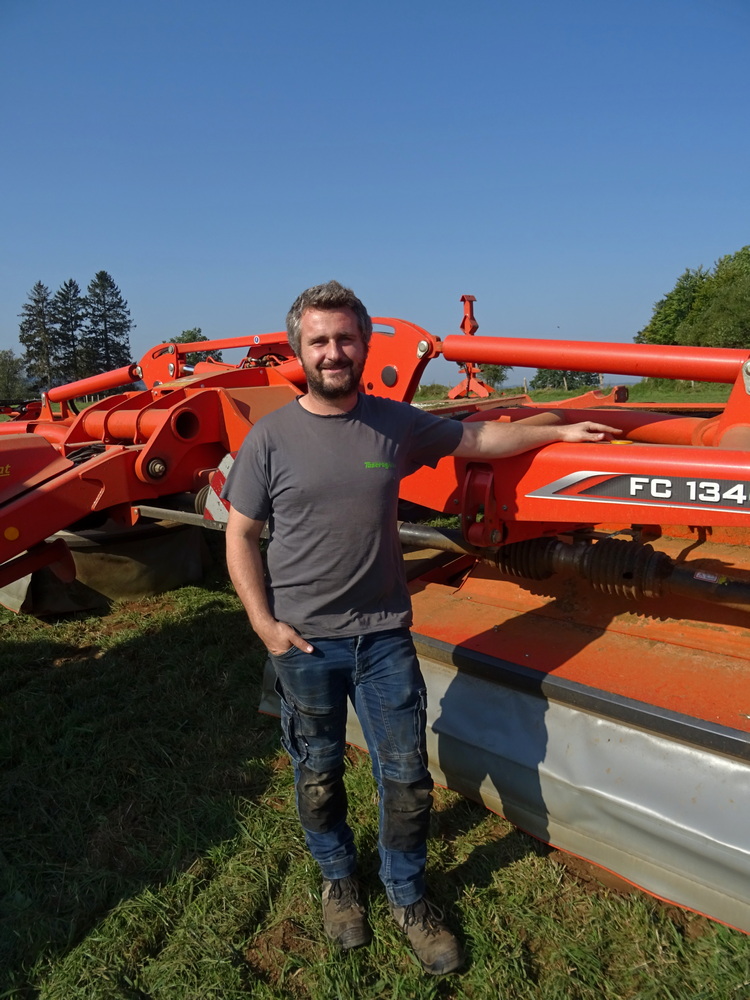 Florent Targnion pose fièrement devant sa faucheuse qui est unique en Belgique.