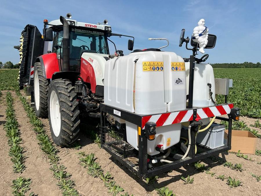 Sur le relevage avant du tracteur, un système de cuves est présent. Il y a un réservoir d’eau et une cuve pour le mélange de la bouillie.