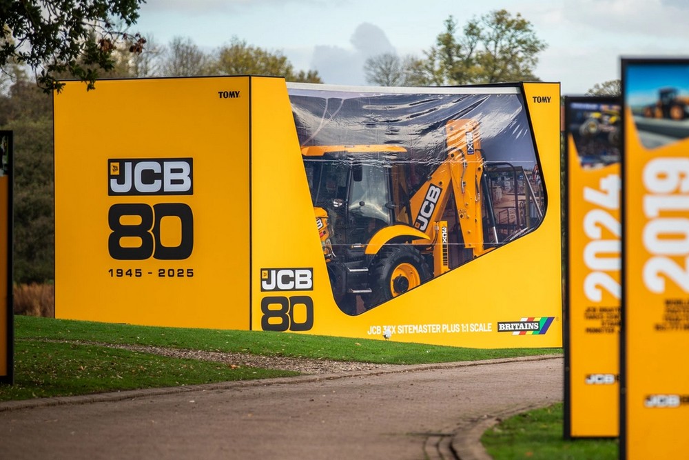 JCB célèbre ses 80 ans avec une édition limitée exclusive Le constructeur britannique JCB fête son 80ᵉ anniversaire avec le lancement d’une série limitée de 80 machines et un retour émouvant aux sources pour son président, Lord Bamford. L’histoire de la marque remonte à 1945 quand Joseph Cyril Bamford a construit sa première remorque agricole dans un simple atelier sans électricité. Celle-ci fut construite à partir de matériaux de récupération de guerre. Aujourd’hui, le groupe compte 22 sites de production dans le monde et plus de 19 000 employés. Une entreprise qui reste fidèle à ses valeurs À l’occasion de cet anniversaire, Lord Bamford, Président de JCB et fils du fondateur de la marque a déclaré : « Mon plus ancien souvenir, c’est moi jouant dans l’atelier de mon père », confie Lord Bamford. « Nous avons énormément fait évoluer nos produits, mais nous restons fidèles à ses valeurs : jamais content et toujours en quête d’une meilleure manière de faire. » Le dirigeant a ensuite rejoint le siège de Rocester, accueilli par plus de 3 500 employés réunis pour saluer son parcours et celui de l’entreprise. Une parade de machines emblématiques, du premier Loadall jusqu’à une machine à hydrogène, a retracé l’histoire d’une marque qui n’a cessé d’innover depuis 1945. 80 machines dans une édition anniversaire exclusive Pour marquer cette étape majeure, 40 4CX PRO DualDrive et 40 télescopiques 542-70 Agripro Loadall seront produites dans une édition anniversaire exclusive. Ces machines haut de gamme se distinguent par leur design noir satiné, des détails chromés et jaunes, ainsi que des sièges brodés et plaques “80ᵉ édition”. Le public a également eu droit au dévoilement d'une JCB 3CX dans une boîte. Cette machine grandeur nature est emballée de la même manière que les modèles réduits à l'échelle 1:32 fabriqués par Britains.