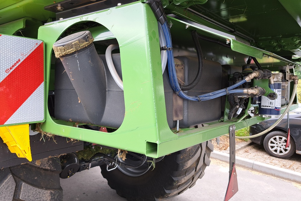 Le système intégré de distribution des additifs d'ensilage se remplit facilement à l'arrière de la remorque.